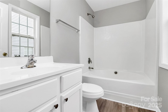 full bathroom featuring vanity, hardwood / wood-style floors, shower / bathtub combination, and toilet