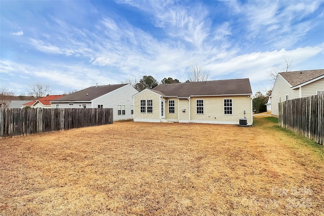 rear view of property featuring a yard and central AC