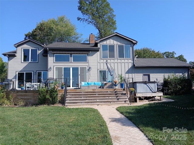 back of house with an outdoor living space, a lawn, a hot tub, and a wooden deck