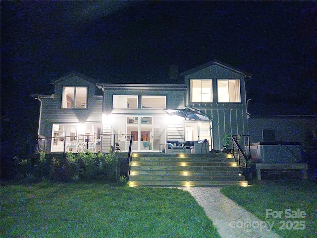 view of front of home with french doors and a yard