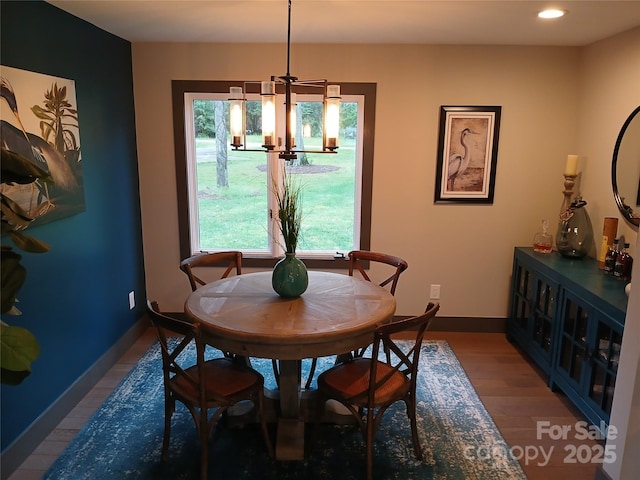 dining area featuring wood-type flooring and a chandelier