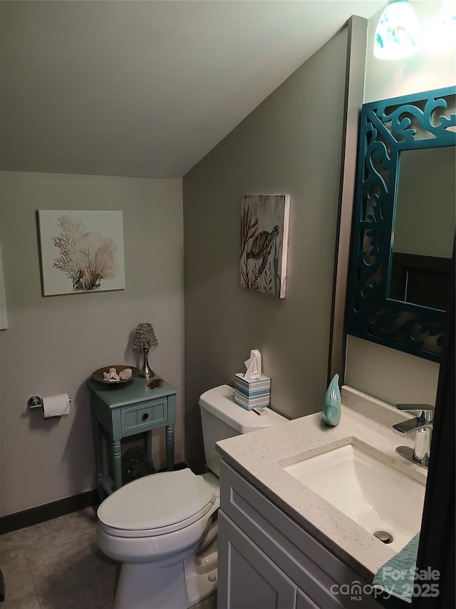 bathroom featuring lofted ceiling, vanity, and toilet