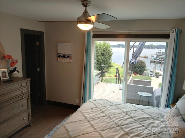 bedroom featuring dark hardwood / wood-style flooring, a water view, access to exterior, and ceiling fan