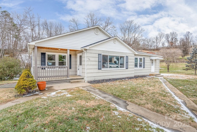 bungalow-style home with a front lawn and a porch