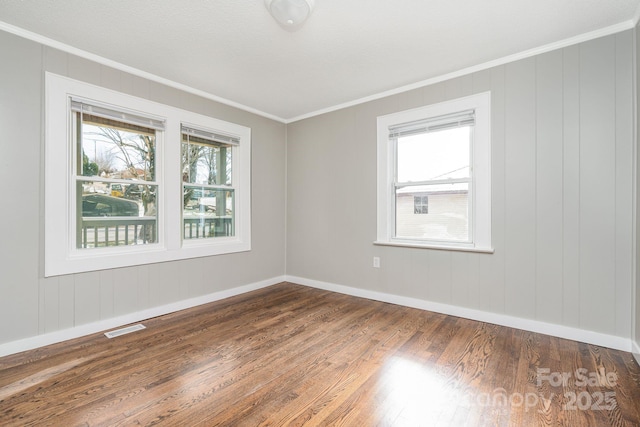 spare room featuring crown molding and dark hardwood / wood-style flooring