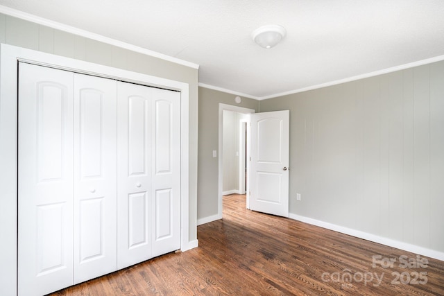 unfurnished bedroom featuring ornamental molding, dark hardwood / wood-style flooring, and a closet