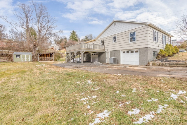 view of home's exterior featuring a deck, a garage, a yard, a shed, and central AC