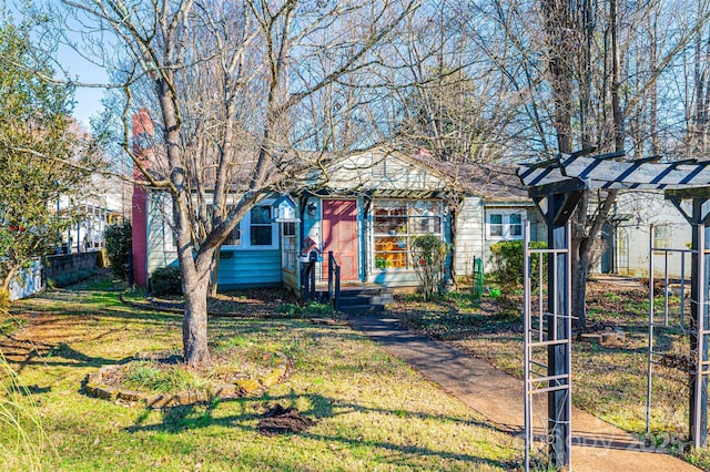 view of front of home with a pergola and a front yard