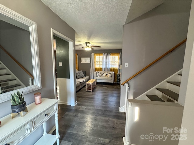 foyer featuring a textured ceiling, ceiling fan, and dark wood-type flooring