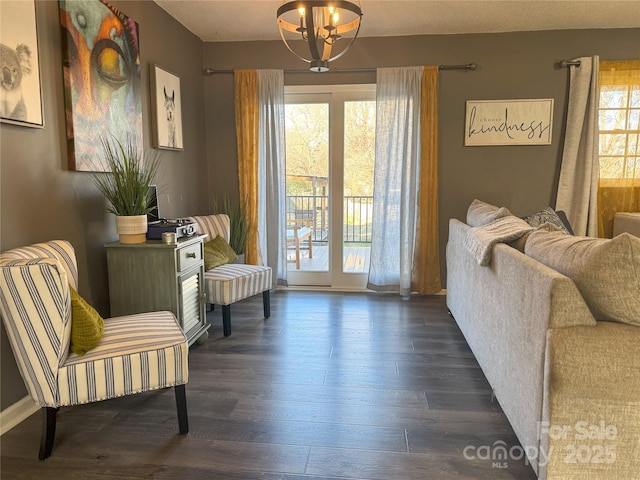 sitting room with a healthy amount of sunlight, a notable chandelier, and dark hardwood / wood-style floors