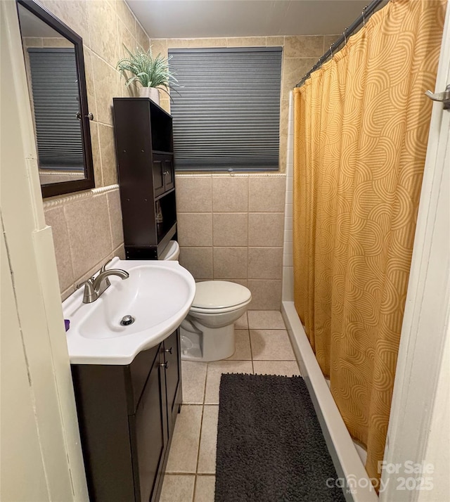 bathroom featuring tile patterned flooring, vanity, and tile walls