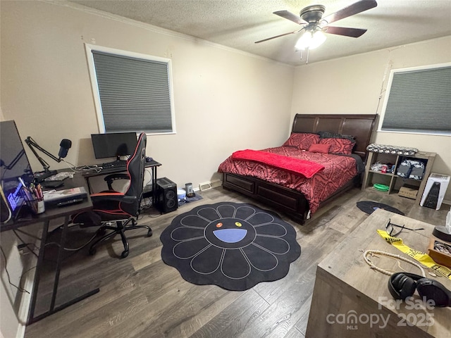 bedroom with ceiling fan, a textured ceiling, hardwood / wood-style flooring, and ornamental molding