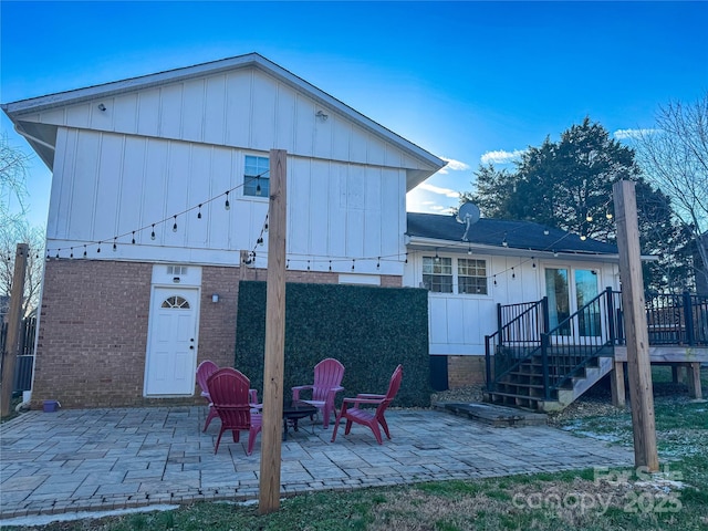 rear view of property with a patio area and an outdoor fire pit