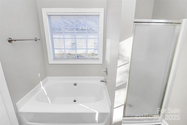 bathroom featuring a garden tub and a shower stall