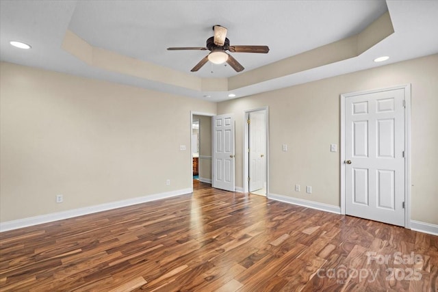 spare room with hardwood / wood-style flooring, ceiling fan, and a tray ceiling