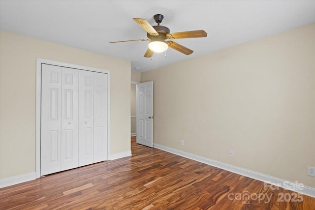 unfurnished bedroom featuring ceiling fan, wood-type flooring, and a closet