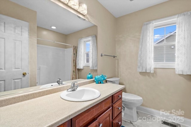 bathroom featuring a wealth of natural light, vanity, toilet, and curtained shower