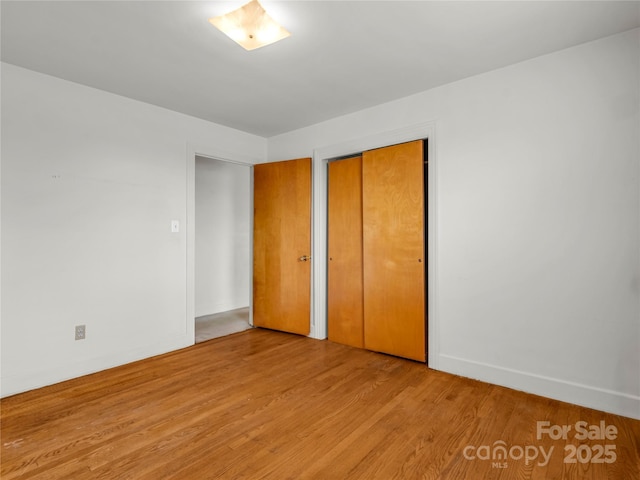 unfurnished bedroom with a closet and light hardwood / wood-style flooring