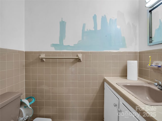 bathroom with vanity, tile walls, and toilet