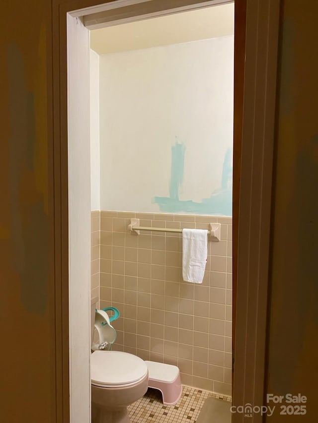 bathroom with tile walls, tile patterned flooring, and toilet