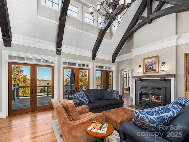 living room with french doors, high vaulted ceiling, plenty of natural light, and a notable chandelier