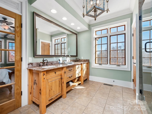 bathroom with an inviting chandelier, crown molding, and vanity