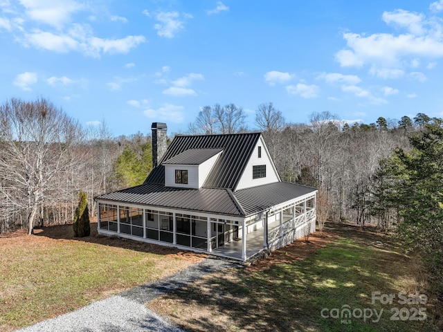 view of front facade featuring a front yard and a sunroom