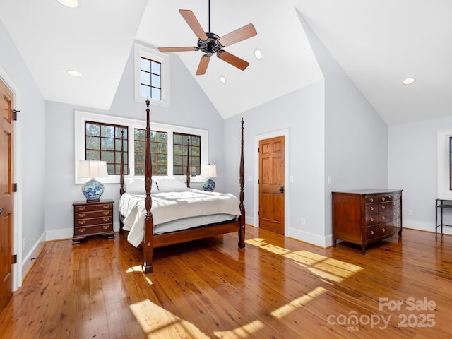 bedroom with ceiling fan, hardwood / wood-style floors, and high vaulted ceiling