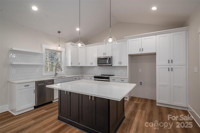 kitchen with sink, stainless steel appliances, a center island, and white cabinetry