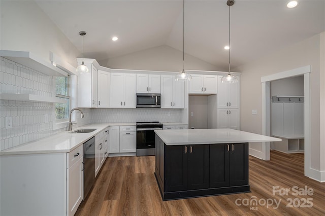 kitchen with pendant lighting, a kitchen island, white cabinets, appliances with stainless steel finishes, and sink