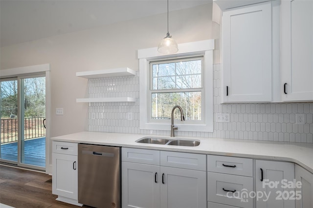 kitchen with sink, hanging light fixtures, white cabinets, and stainless steel dishwasher