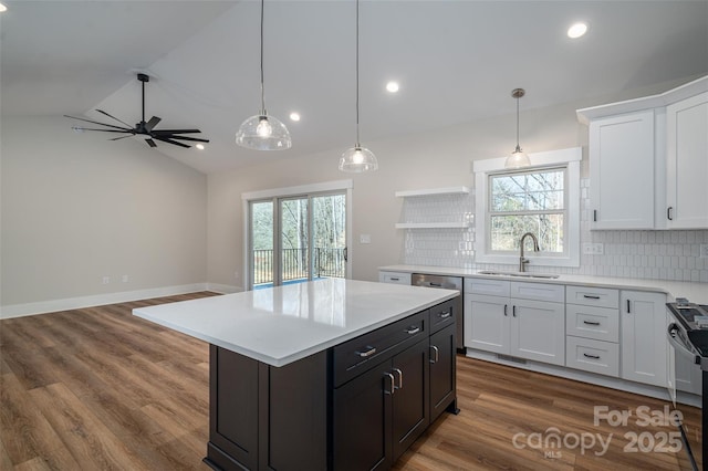 kitchen with sink, a center island, white cabinetry, lofted ceiling, and tasteful backsplash