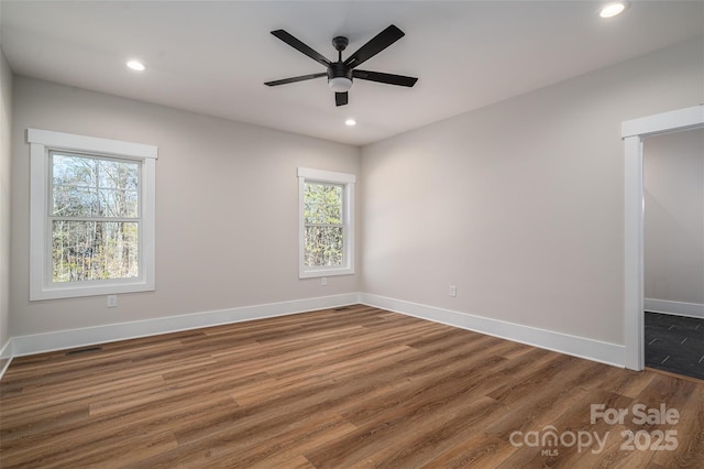 spare room featuring ceiling fan and dark wood-type flooring