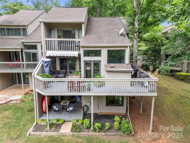 rear view of house with a deck and a lawn