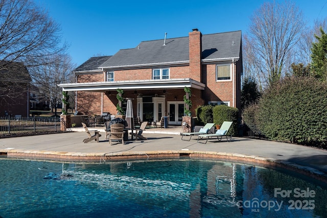 back of house featuring a patio, french doors, and a fenced in pool