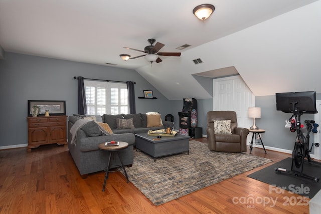 living room with ceiling fan, vaulted ceiling, and dark wood-type flooring