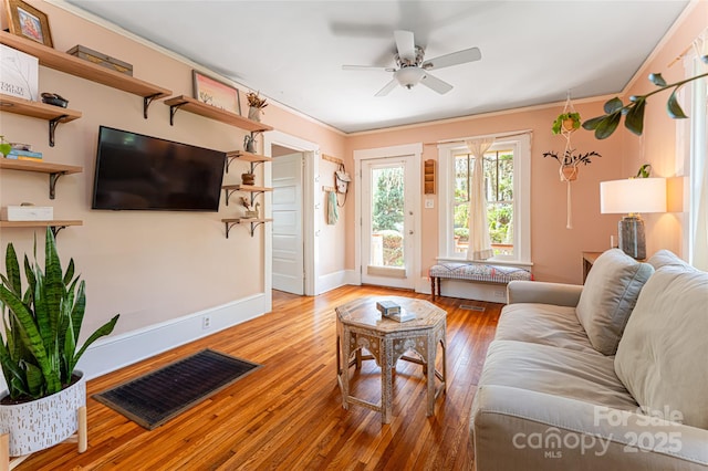 living room with ceiling fan, crown molding, and light hardwood / wood-style flooring