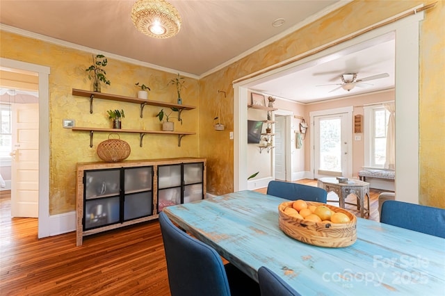 dining space with dark wood-type flooring, crown molding, and ceiling fan