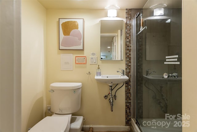 bathroom with toilet, walk in shower, and sink