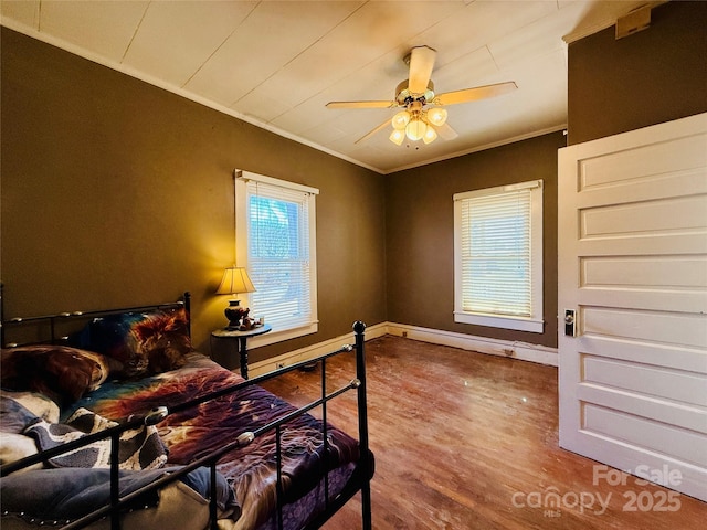 bedroom featuring ceiling fan, wood-type flooring, and crown molding