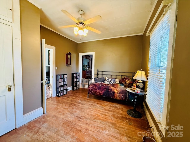 bedroom featuring light hardwood / wood-style floors, ceiling fan, and ornamental molding