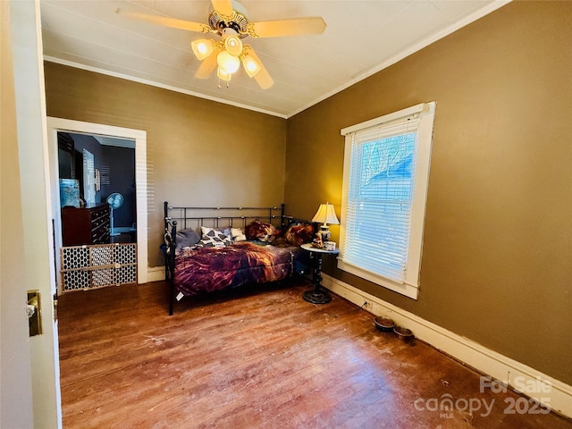 bedroom with hardwood / wood-style floors, ceiling fan, and crown molding