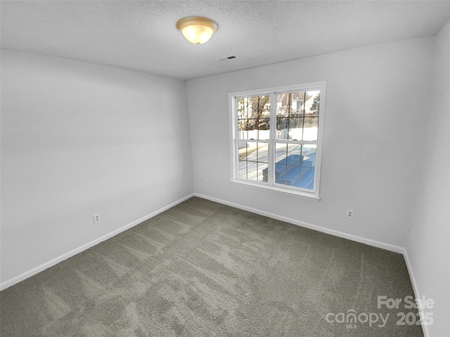 carpeted empty room with a textured ceiling