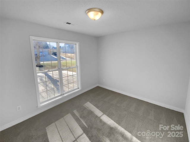 unfurnished room with dark colored carpet