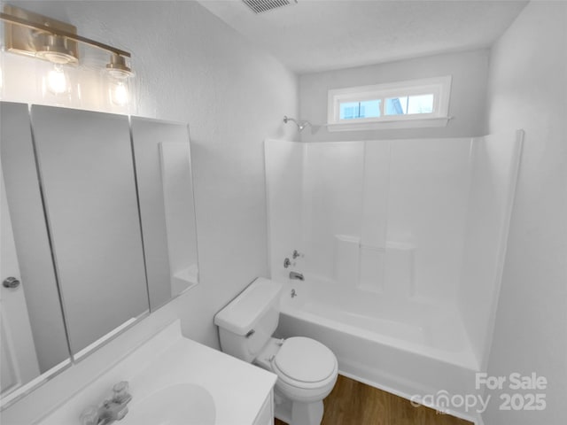 full bathroom with hardwood / wood-style floors, vanity, toilet, and bathtub / shower combination