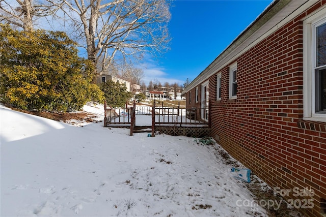 snowy yard featuring a deck