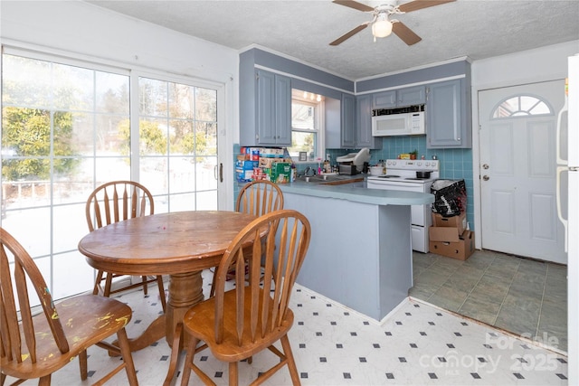 kitchen with white appliances, a textured ceiling, decorative backsplash, kitchen peninsula, and ceiling fan