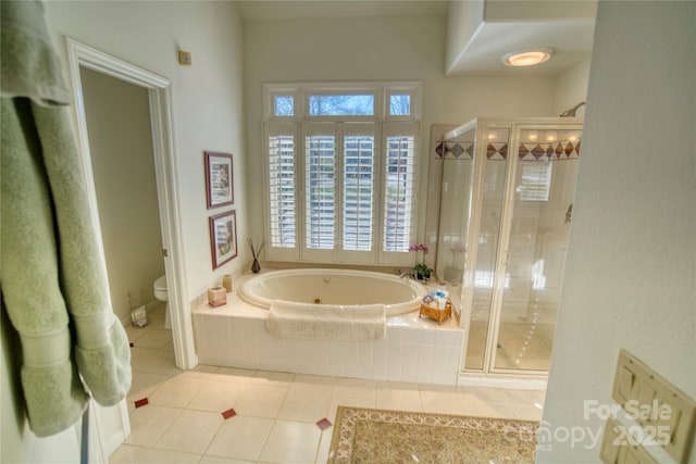 bathroom featuring tile patterned floors, toilet, and independent shower and bath