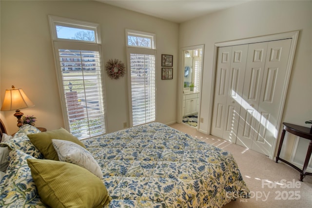 bedroom featuring light colored carpet and a closet