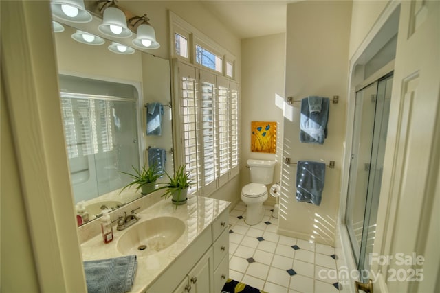 bathroom with toilet, vanity, tile patterned flooring, and an enclosed shower